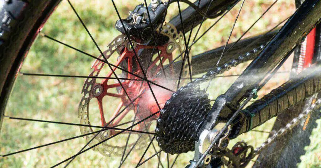 image of a e-bike backwheel being cleaned using a hosepipe