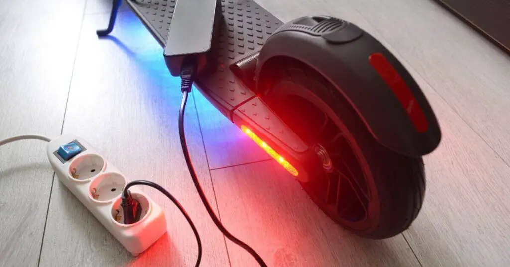 image of an electric scooter being charged up and the back light shining bright red