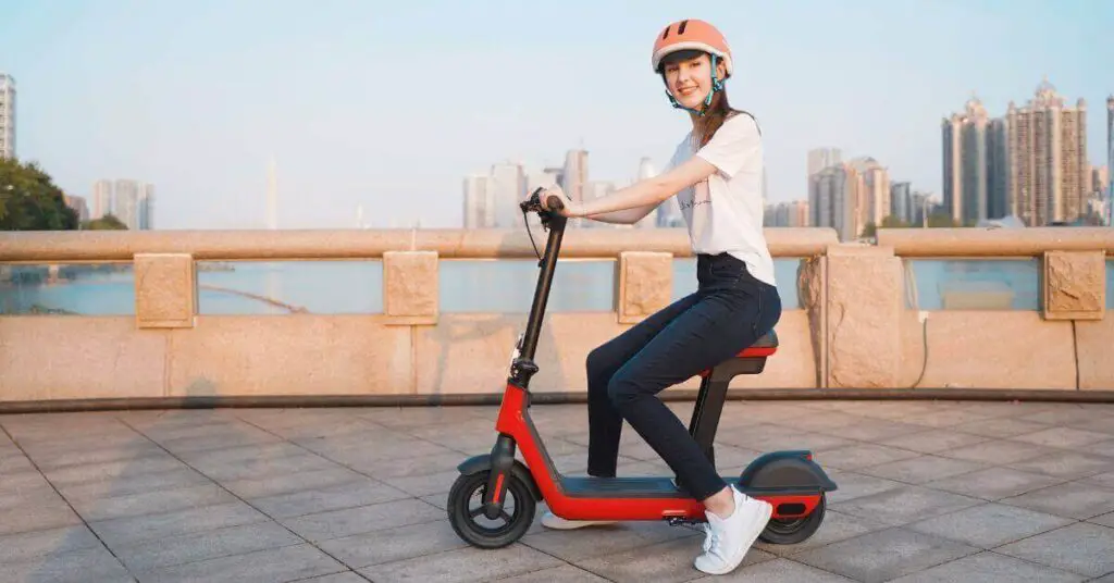 an image of a woman riding an electric scooter on a bridge with a city in the background